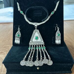 Silver necklace and earrings with green jade color stones.